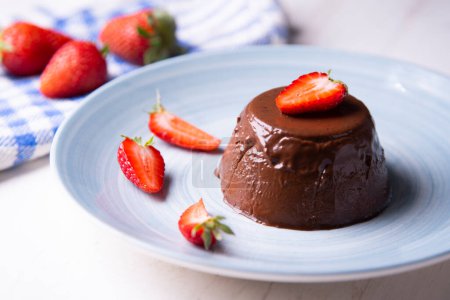 Photo for Chocolate Panna Cotta. Panna cotta is a typical dessert from the Italian region of Piedmont, made from milk or cream, sugar and gelling agents, which is usually garnished with red fruit jams. - Royalty Free Image