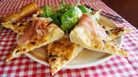 Foto de Focaccia es una especie de pan plano cubierto de hierbas y otros productos alimenticios. Es un plato italiano tradicional estrechamente relacionado con la pizza popular. - Imagen libre de derechos