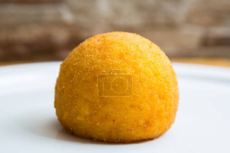 Photo for Arancini are a specialty of Sicilian cuisine. They are deep-fried, breaded rice balls or cones 812 cm in diameter, usually filled with rag, peas and cheese, or diced ham and mozzarella. - Royalty Free Image
