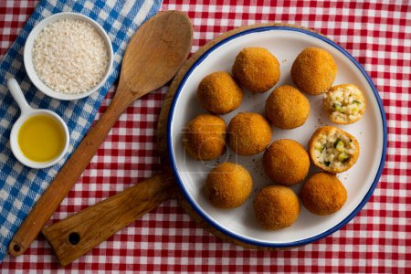 Foto de Arancini es una especialidad de la cocina siciliana. Son bolas de arroz o conos fritos y empanados de 812 cm de diámetro, generalmente rellenos de trapo, guisantes y queso, o jamón picado y mozzarella.. - Imagen libre de derechos
