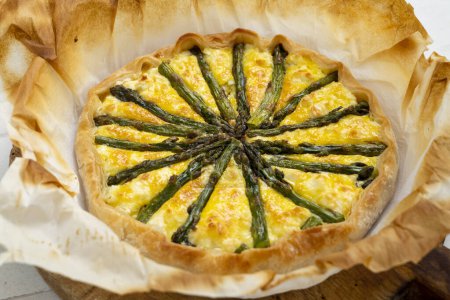 Photo for Green asparagus quiche. A quiche is a type of savory tart derived from the French quiche lorraine. It is made with a preparation of beaten eggs and thick fresh milk cream, mixed with chopped vegetables, and/or meat products. - Royalty Free Image