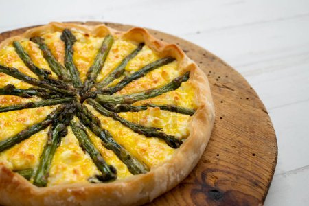 Photo for Green asparagus quiche. A quiche is a type of savory tart derived from the French quiche lorraine. It is made with a preparation of beaten eggs and thick fresh milk cream, mixed with chopped vegetables, and/or meat products. - Royalty Free Image