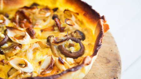 Photo for Mushroom quiche. A quiche is a type of savory tart derived from the French quiche lorraine. It is made with a preparation of beaten eggs and thick fresh milk cream, mixed with chopped vegetables, and/or meat products. - Royalty Free Image