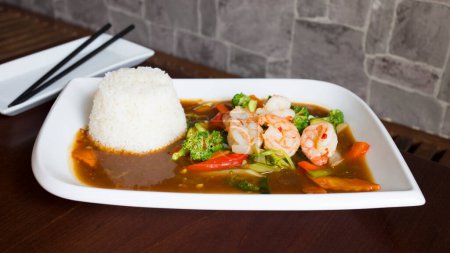 Foto de Langostinos y verduras. Placa combinada asiática con mariscos y arroz. - Imagen libre de derechos