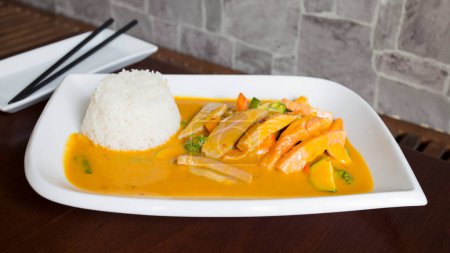 Téléchargez les photos : Assiette asiatique combo avec poulet en sauce au curry et légumes servis avec du riz. - en image libre de droit