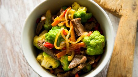 Photo for Beef strips cooked in soy sauce with steamed vegetables such as broccoli and carrots. - Royalty Free Image