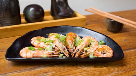 Photo for Black plate with grilled shrimps in a Japanese restaurant - Royalty Free Image