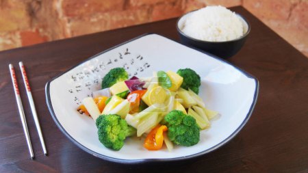 Téléchargez les photos : Légumes cuits à la vapeur comme le brocoli et la carotte avec un bol de riz sur le côté dans un restaurant chinois. - en image libre de droit