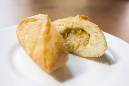 Photo for Pirozhki are stuffed rolls typical of Russian, Belarusian, and Ukrainian cuisines. They can be baked or fried with yeast. Their fillings are made of meat or vegetables. - Royalty Free Image