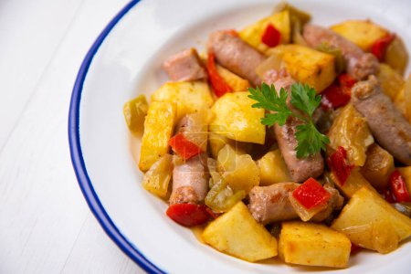 Téléchargez les photos : Plat avec saucisses de porc et pommes de terre. Recette de tapa espagnole traditionnelle. - en image libre de droit