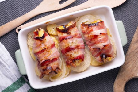 Téléchargez les photos : Poulet cuit au four enveloppé de bacon. - en image libre de droit