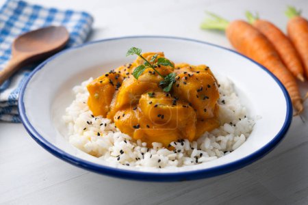 Téléchargez les photos : Recette de poulet avec sauce au curry et carotte. Servi avec riz et salade. - en image libre de droit