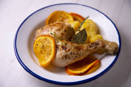 Téléchargez les photos : Poulet braisé mariné aux épices et sauce orange aux pommes de terre. - en image libre de droit