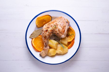 Téléchargez les photos : Poulet braisé mariné aux épices et sauce orange aux pommes de terre. - en image libre de droit