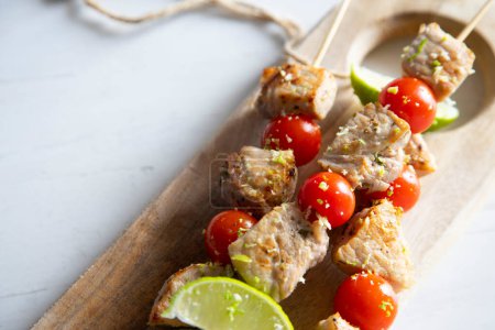 Foto de Brochetas de pollo marinado con lima y verduras. - Imagen libre de derechos