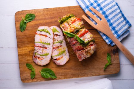 Photo for Baked pork loin stuffed with pesto, mozzarella and tomato. Traditional Italian recipe. - Royalty Free Image