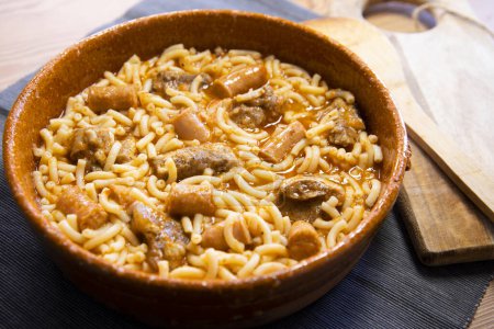 Photo for Baked noodles with pork rib, sausages and tomato. Traditional spanish tapa. - Royalty Free Image