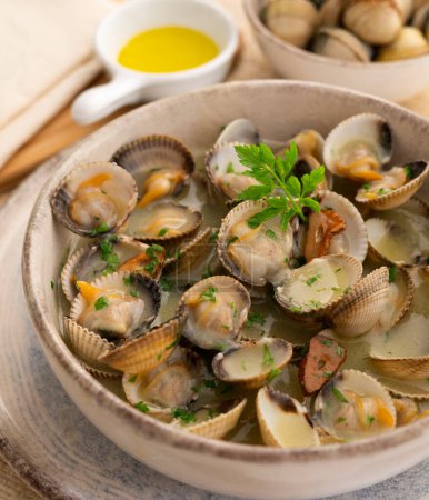 Photo for Steamed clams with white wine sauce and vegetables. Traditional Spanish tapa recipe. - Royalty Free Image