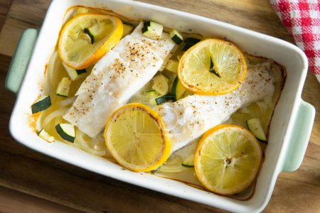Photo for Baked cod cooked with lemon and onion. Traditional Spanish tapa recipe in the Basque country. - Royalty Free Image
