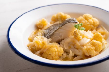 Foto de Bacalao al horno cocido con patata y coliflor. Receta tradicional de tapa española en el País Vasco. - Imagen libre de derechos