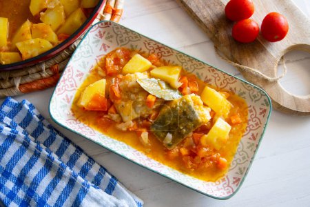 Photo for Baked cod cooked with potatoes and vegetables.. Traditional Spanish tapa recipe in the Basque country. - Royalty Free Image