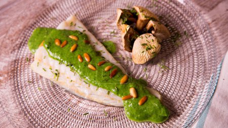 Photo for Baked cod cooked with spinach sauce. Traditional Spanish tapa recipe in the Basque country. - Royalty Free Image