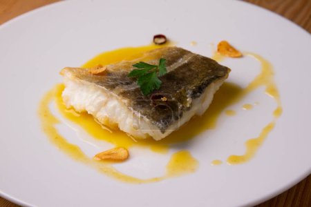 Photo for Pilpil cod is a traditional Basque dish made with four basic ingredients: cod, olive oil, garlic and chillies. A clay pot is usually used as a general rule in its preparation. - Royalty Free Image
