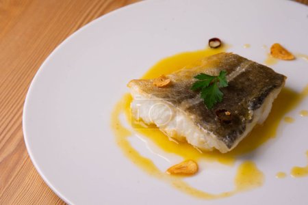 Photo for Pilpil cod is a traditional Basque dish made with four basic ingredients: cod, olive oil, garlic and chillies. A clay pot is usually used as a general rule in its preparation. - Royalty Free Image