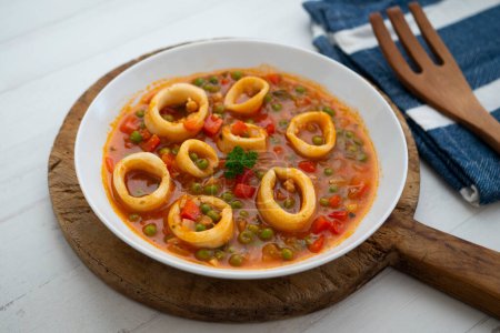 Foto de Calamar guisado con salsa de tomate y cebolla. Tapa tradicional española. - Imagen libre de derechos