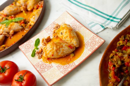 Téléchargez les photos : Calmar cuit avec sauce tomate et oignon farcie de légumes. Tapa espagnol traditionnel. - en image libre de droit
