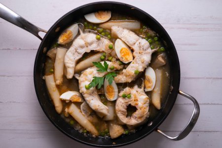 Foto de Congrio de anguila cocido en el horno con alcachofas y huevo duro. - Imagen libre de derechos
