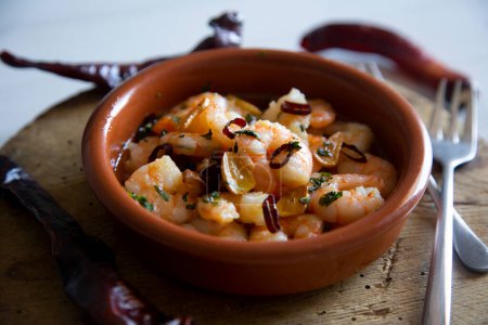 Téléchargez les photos : Tapa espagnole traditionnelle de gambas al ajillo. Crevettes cuites à l'huile d'olive et à l'ail. - en image libre de droit