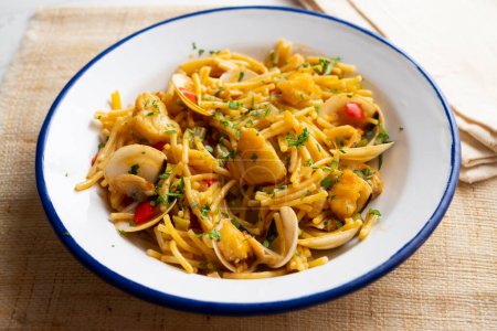 Photo for Traditional Spanish tapa of noodles with monkfish. Cooked in a fideu style paella. - Royalty Free Image