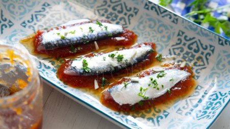 Foto de Sardinas marinadas servidas sobre mermelada de tomate. - Imagen libre de derechos