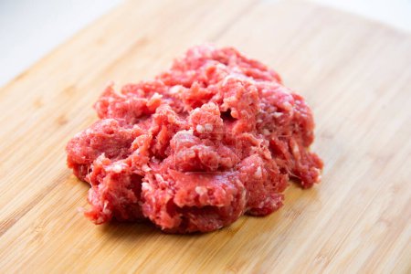 Photo for Premium minced beef on wood base on a white background. - Royalty Free Image
