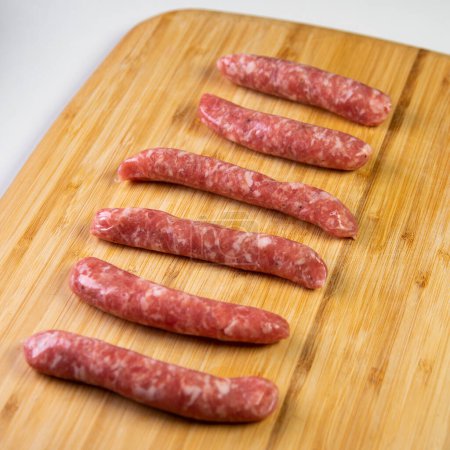 Photo for Premium minced pork sausages on a wood on a white background. - Royalty Free Image