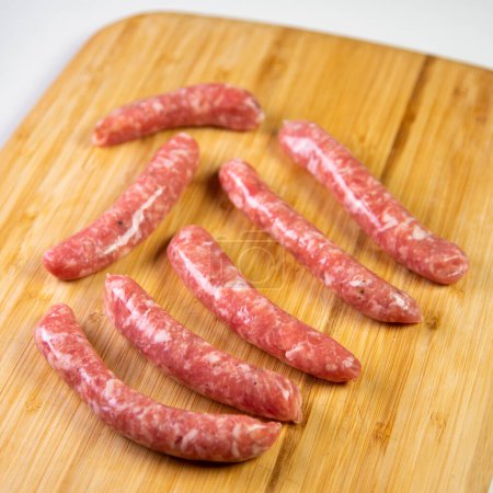 Photo for Premium minced pork sausages on a wood on a white background. - Royalty Free Image