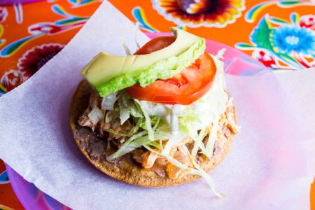 Photo for Tostada with avocado. Tostada, name given to various dishes in Mexico that include a toasted tortilla as the main base of its preparation. - Royalty Free Image