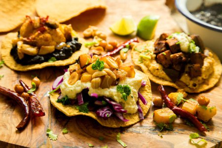 Photo for Tostada mejicana with hummus, corn and red cabbage. Tostada, name given to various dishes in Mexico that include a toasted tortilla as the main base of its preparation. - Royalty Free Image