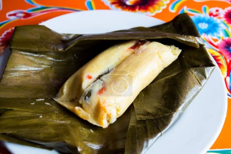 Photo for A tamale, in Spanish tamal, is a traditional Mesoamerican dish made of masa, a dough made from nixtamalized corn, which is steamed in a banana or corn leaf. - Royalty Free Image