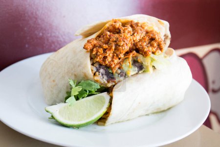 Foto de Un burrito es un plato de cocina Mexicana y Tex-Mex que se formó en Ciudad Jurez y consiste en una tortilla de harina envuelta en forma cilíndrica sellada alrededor de varios ingredientes.. - Imagen libre de derechos
