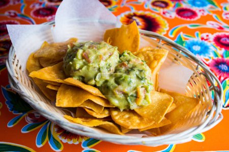 Photo for Nachos with guacamole. Nachos are a dish of Mexican origin, which consists of frying pieces of corn tortilla covered with a special cheese. - Royalty Free Image