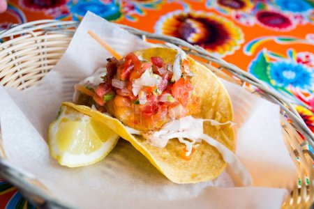 Téléchargez les photos : Taco aux crevettes avec pico de gallo. Un taco est un aliment traditionnel mexicain composé d'une petite tortilla de maïs à la main - en image libre de droit
