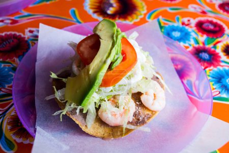 Photo for Taco with avocado and prawns. A taco is a traditional Mexican food consisting of a small hand-sized corn tortilla - Royalty Free Image