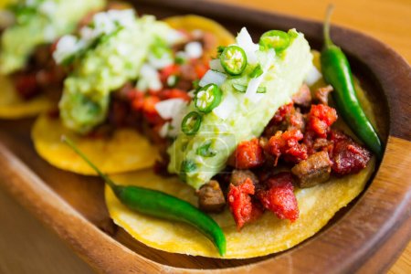 Photo for Delicatessen taco with chorizo and guacamole. A taco is a traditional Mexican food consisting of a small hand-sized corn tortilla - Royalty Free Image