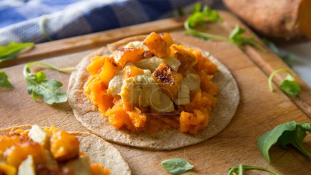 Photo for Chicken, pinneaple and sweet potato taco. A taco is a traditional Mexican food consisting of a small hand-sized corn tortilla - Royalty Free Image