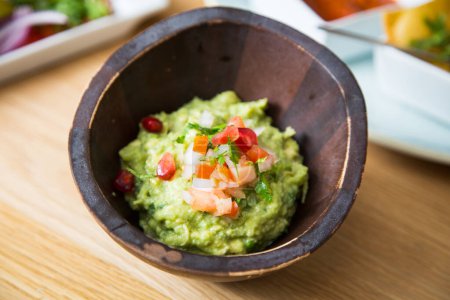 Photo for Guacamole is an avocado-based dip, spread, or salad first developed in Mexico. - Royalty Free Image