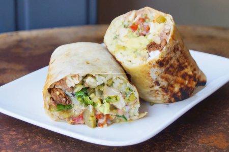 Téléchargez les photos : Un burrito est un plat de la cuisine mexicaine et Tex-Mex qui a été formé à Ciudad Jurez et se compose d'une tortilla de farine enveloppée dans une forme cylindrique scellée autour de divers ingrédients. - en image libre de droit