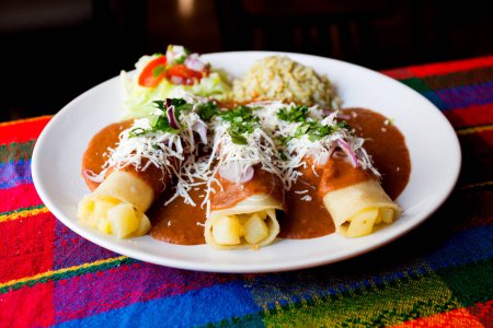 Foto de Flautas es un plato de la gastronomía mexicana y es parte de lo que se conoce como "snacks mexicanos". El plato se compone de tacos hechos de tortillas de maíz laminado y frito o tortillas de harina, que pueden tener diferente contenido - Imagen libre de derechos
