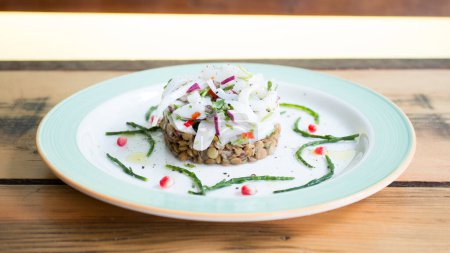 Téléchargez les photos : Ceviche avec calmar et lentilles. Ceviche est un petit apéritif traditionnel latino-américain composé de morceaux de fruits de mer crus ou de poisson dans une marinade acide. - en image libre de droit
